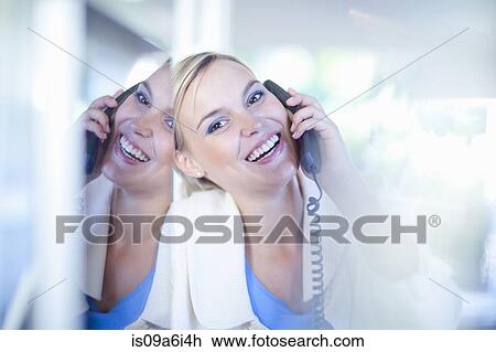 Businesswoman talking on phone at desk View Large Photo Image Stock Image - Businesswoman talking on phone at desk. Fotosearch
