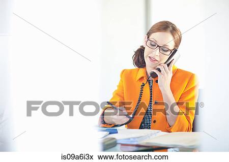 Businesswoman talking on phone at desk View Large Photo Image Stock Photo - Businesswoman talking on phone at desk. Fotosearch