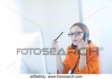 Stock Photo - Businesswoman talking on phone at desk. Fotosearch