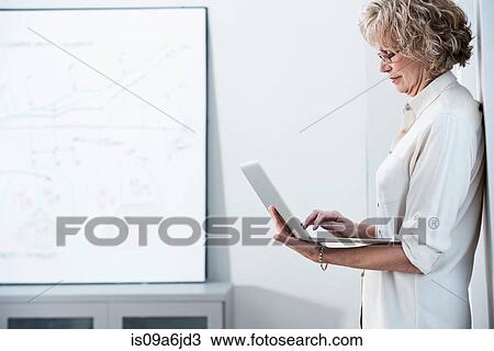 Businesswoman using laptop in office View Large Photo Image Stock Image - Businesswoman using laptop in office. Fotosearch