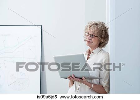 Stock Photography - Businesswoman using laptop in office. Fotosearch