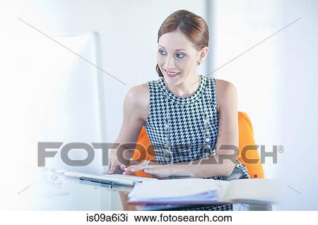 Businesswoman working at desk View Large Photo Image Stock Image - Businesswoman working at desk. Fotosearch
