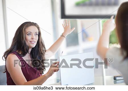 Stock Image - Businesswomen pointing to graph. Fotosearch