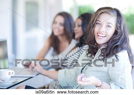 Businesswomen sitting at desk View Large Photo Image Picture - Businesswomen sitting at desk. Fotosearch