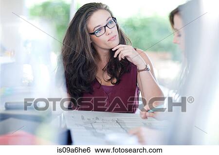 Stock Photograph - Businesswomen talking in meeting. Fotosearch