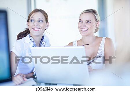 Businesswomen working on laptop View Large Photo Image Stock Image - Businesswomen working on laptop. Fotosearch