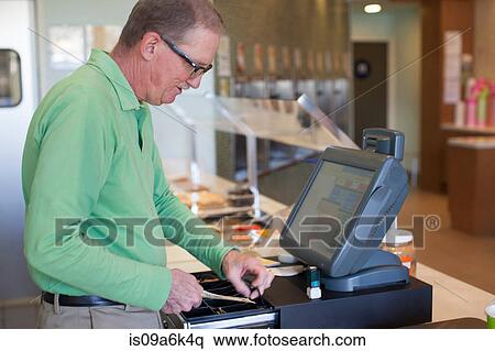 Cashier operating till in store View Large Photo Image Stock Photography - Cashier operating till in store. Fotosearch