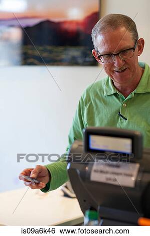 Cashier running credit card in store View Large Photo Image Stock Photograph - Cashier running credit card in store. Fotosearch