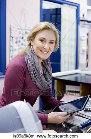Cashier using tablet computer in store View Large Photo Image Picture - Cashier using tablet computer in store. Fotosearch