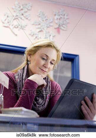 Cashier using tablet computer in store View Large Photo Image Stock Image - Cashier using tablet computer in store. Fotosearch