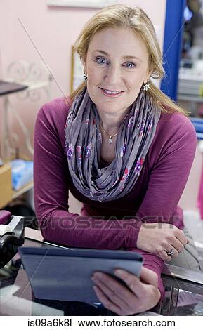 Stock Image - Cashier using tablet computer in store. Fotosearch