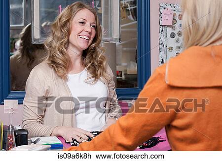 Stock Image - Cashier working in thrift store. Fotosearch