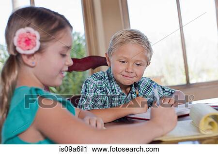 Stock Image - Children doing homework together. Fotosearch