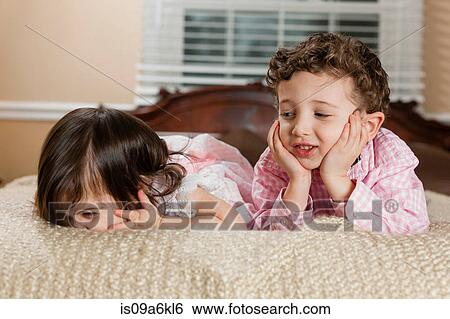 Children laying on bed View Large Photo Image Stock Photograph - Children laying on bed. Fotosearch