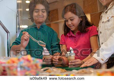 Children putting toppings on yogurt View Large Photo Image Stock Photo - Children putting toppings on yogurt. Fotosearch
