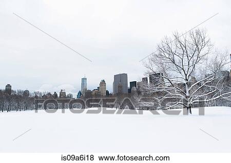 Stock Photo - City skyline and snowy urban park. Fotosearch