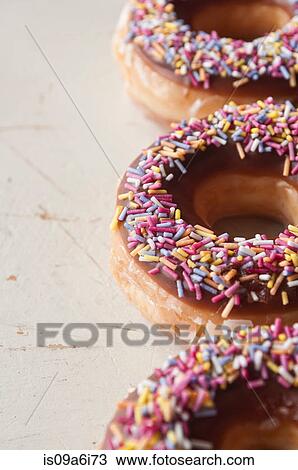 Stock Image - Close up of decorated doughnuts. Fotosearch