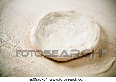 Picture - Close up of pizza dough being flattened. Fotosearch