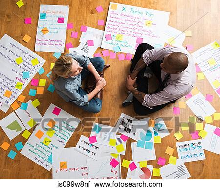 Colleagues sitting cross legged on floor with papers and adhesive notes View Large Photo Image Stock Image - Colleagues sitting cross legged on floor with papers and adhesive notes. Fotosearch