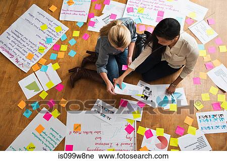 Colleagues sitting on floor with papers and adhesive notes View Large Photo Image Stock Image - Colleagues sitting on floor with papers and adhesive notes. Fotosearch
