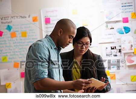 Stock Photo - Colleagues using digital tablet. Fotosearch