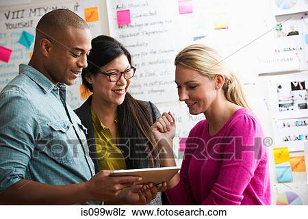Colleagues using digital tablet View Large Photo Image Stock Photo - Colleagues using digital tablet. Fotosearch