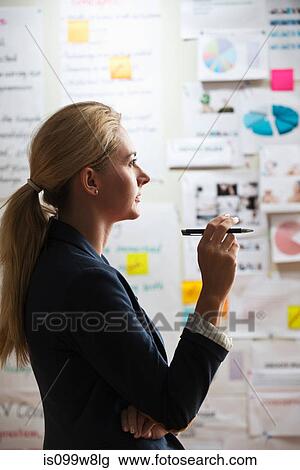 Contemplative woman holding pen View Large Photo Image Stock Image - Contemplative woman holding pen. Fotosearch