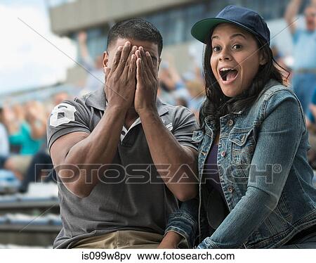 Stock Photo - Couple caught on camera at sports game. Fotosearch