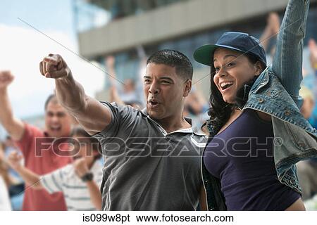 Couple cheering at sports game View Large Photo Image Stock Photograph - Couple cheering at sports game. Fotosearch