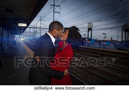 Picture - Couple kissing at train station. Fotosearch