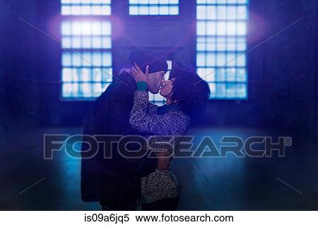 Stock Photography - Couple kissing in empty warehouse. Fotosearch