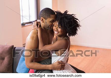 Couple kissing on sofa in living room View Large Photo Image Picture - Couple kissing on sofa in living room. Fotosearch