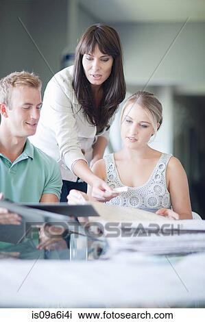Stock Image - Couple looking at paint swatches. Fotosearch
