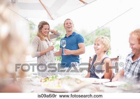 Stock Photography - Couple making toast at table. Fotosearch