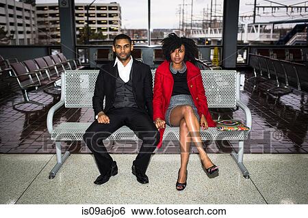 Stock Photograph - Couple on bench at train station. Fotosearch