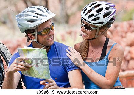 Couple reading map on mountain bikes View Large Photo Image Stock Photo - Couple reading map on mountain bikes. Fotosearch