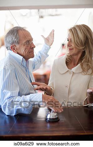 Stock Photo - Couple ringing bell in hotel lobby. Fotosearch