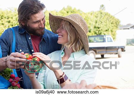 Stock Image - Couple shopping at farmer's market. Fotosearch
