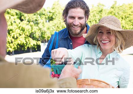 Stock Photo - Couple shopping at farmer's market. Fotosearch