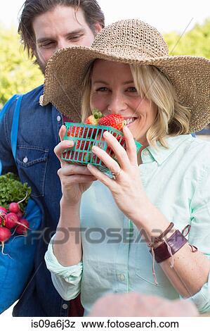 Stock Photo - Couple shopping at farmer's market. Fotosearch