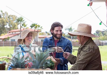 Stock Photograph - Couple shopping at farmer's market. Fotosearch