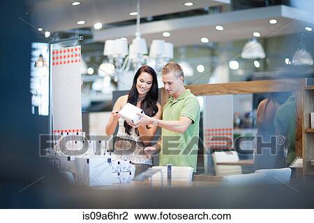 Stock Image - Couple shopping for kitchenware in store. Fotosearch