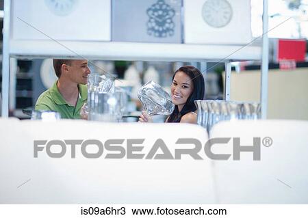 Stock Image - Couple shopping for kitchenware in store. Fotosearch