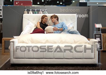Stock Image - Couple shopping for mattress in store. Fotosearch