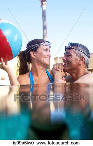 Stock Image - Couple swimming together in pool. Fotosearch