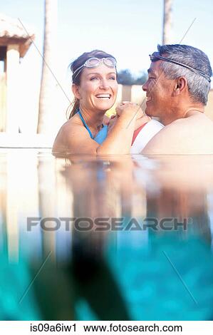 Stock Image - Couple swimming together in pool. Fotosearch