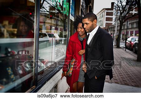 Stock Photo - Couple window shopping on city street. Fotosearch