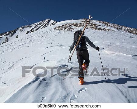 Cross country skier hiking up slope View Large Photo Image Stock Image - Cross country skier hiking up slope. Fotosearch