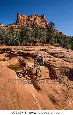 Stock Photo - Dirt biker in dry desert landscape. Fotosearch