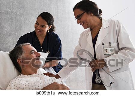 Doctor and nurse with patient View Large Photo Image Stock Photograph - Doctor and nurse with patient. Fotosearch
